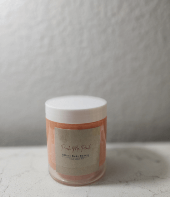 Pinch Me Peach Body Buffer scrub in a jar on a marble surface, perfect for self-care routines and skin exfoliation.